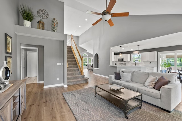 4008 Ryleland Ct, Powell, OH 43065 - living room with high vaulted ceiling, arched walkways, light wood-style flooring, plenty of natural light, and a ceiling fan