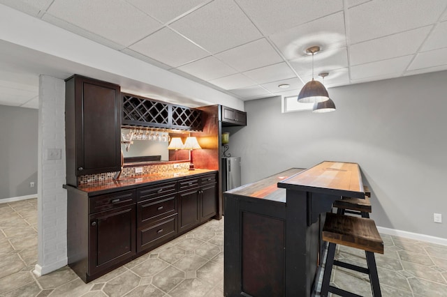 4008 Ryleland Ct, Powell, OH 43065 - indoor dry bar featuring a drop ceiling, hanging light fixtures, and baseboards