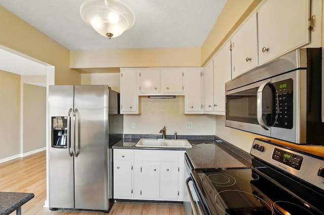 662 Pamlico St Unit Z7, Columbus, OH 43228 - kitchen with appliances with stainless steel finishes, a sink, light wood-style floors, and white cabinetry