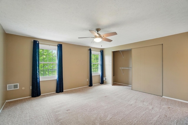 662 Pamlico St Unit Z7, Columbus, OH 43228 - unfurnished bedroom with multiple windows, a closet, carpet flooring, and a textured ceiling