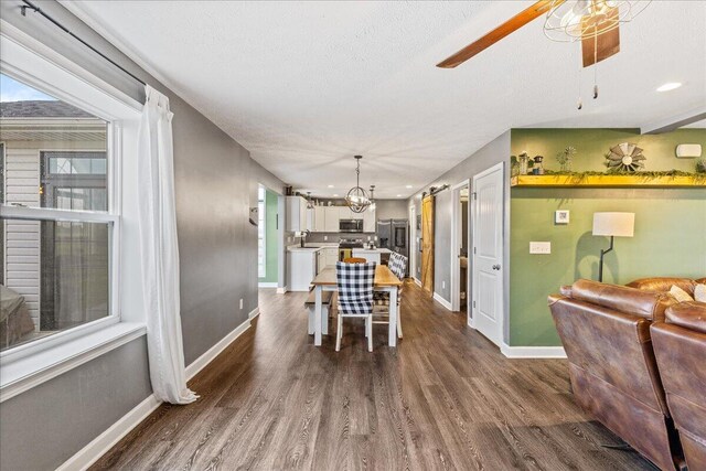 2460 N Court St, Circleville, OH 43113 - dining area with baseboards, a ceiling fan, dark wood-style flooring, a chandelier, and a textured ceiling