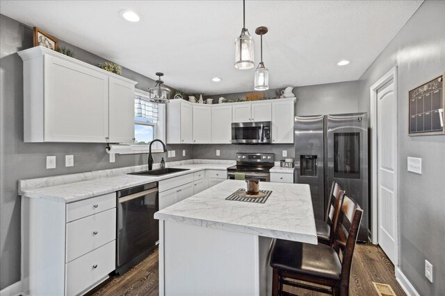 2460 N Court St, Circleville, OH 43113 - kitchen with appliances with stainless steel finishes, a sink, dark wood-type flooring, a kitchen island, and white cabinetry