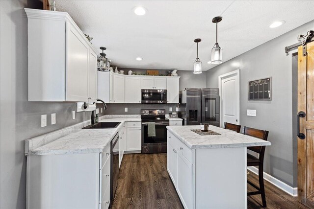 2460 N Court St, Circleville, OH 43113 - kitchen with stainless steel appliances, a sink, a barn door, dark wood-type flooring, and white cabinetry