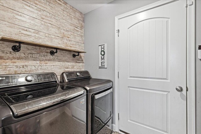 2460 N Court St, Circleville, OH 43113 - clothes washing area featuring wooden walls and washer and clothes dryer
