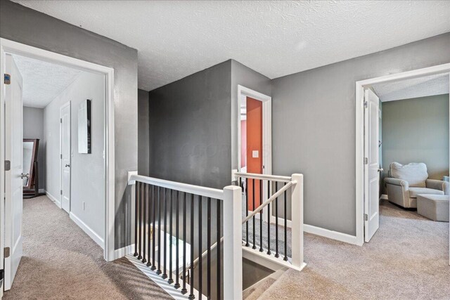 2460 N Court St, Circleville, OH 43113 - hallway featuring an upstairs landing, carpet flooring, a textured ceiling, and baseboards