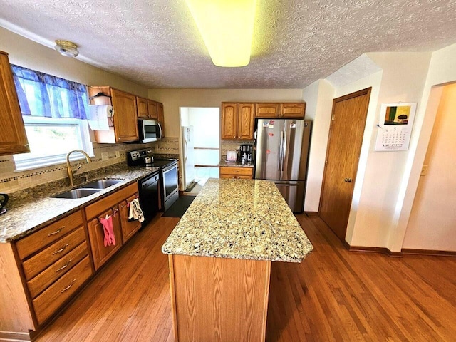464 Highbanks Valley Dr, Newark, OH 43055 - kitchen with appliances with stainless steel finishes, a sink, a kitchen island, dark wood-type flooring, and a textured ceiling