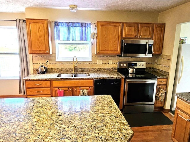 464 Highbanks Valley Dr, Newark, OH 43055 - kitchen featuring stainless steel appliances, a sink, backsplash, dark wood finished floors, and brown cabinets