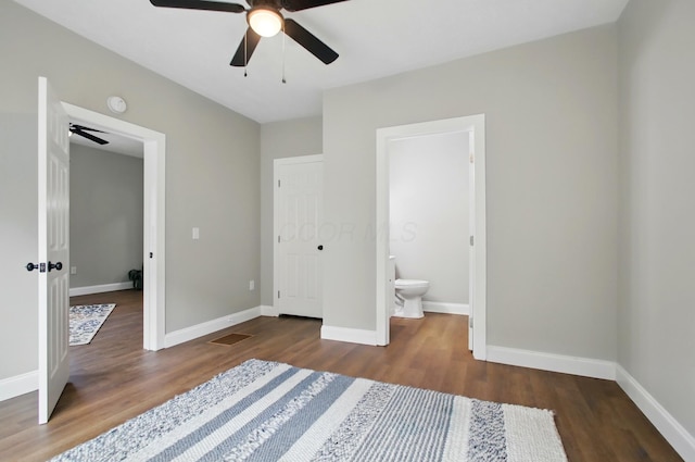 unfurnished bedroom featuring wood finished floors, baseboards, and ensuite bathroom