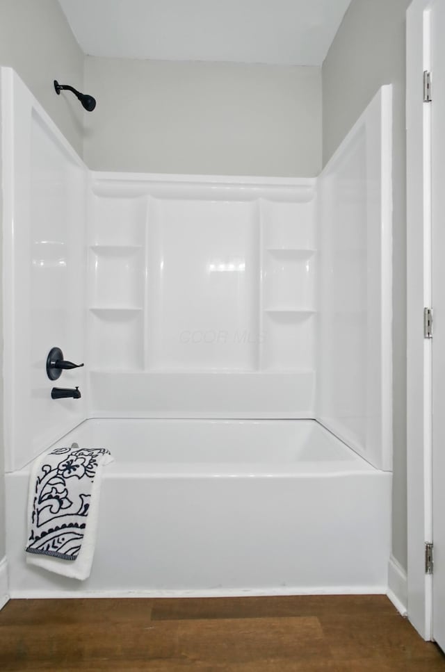 bathroom featuring shower / bathtub combination, baseboards, and wood finished floors