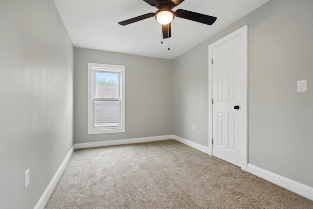 carpeted empty room with baseboards and ceiling fan