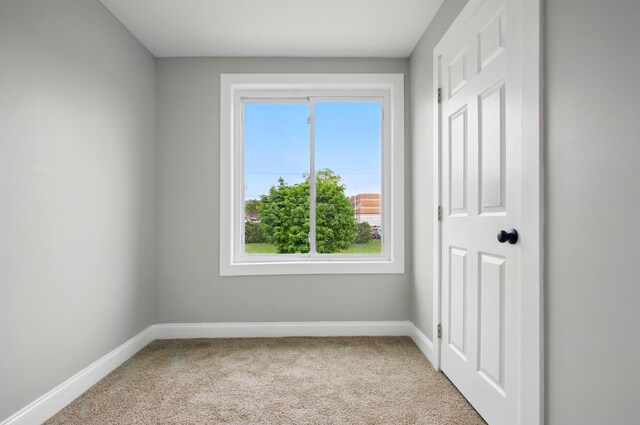 carpeted empty room with baseboards