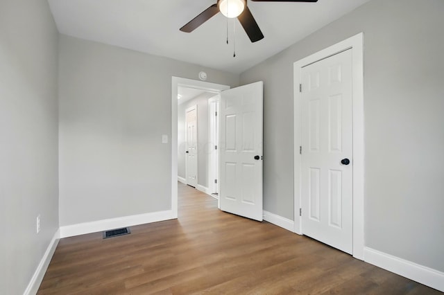 unfurnished bedroom featuring baseboards, wood finished floors, and a ceiling fan