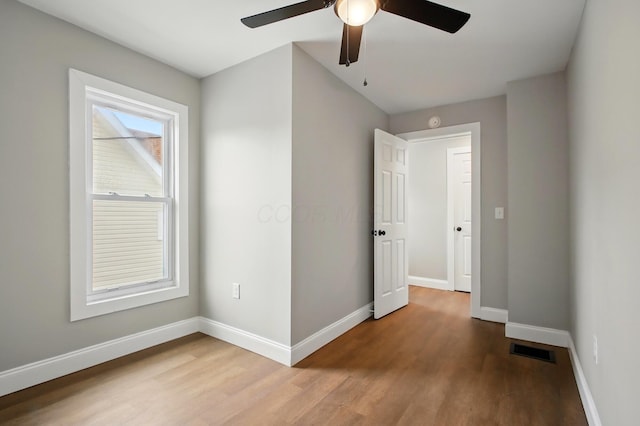 unfurnished bedroom with wood finished floors, baseboards, and ceiling fan