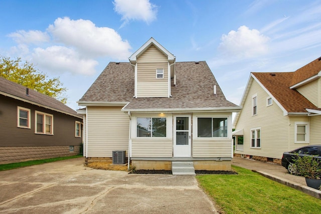 view of front of property featuring a shingled roof, central AC, entry steps, and a front lawn