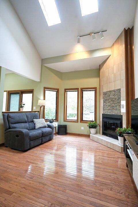 532 Woodview Rd, Westerville, OH 43081 - living room featuring high vaulted ceiling, a fireplace, wood finished floors, and track lighting