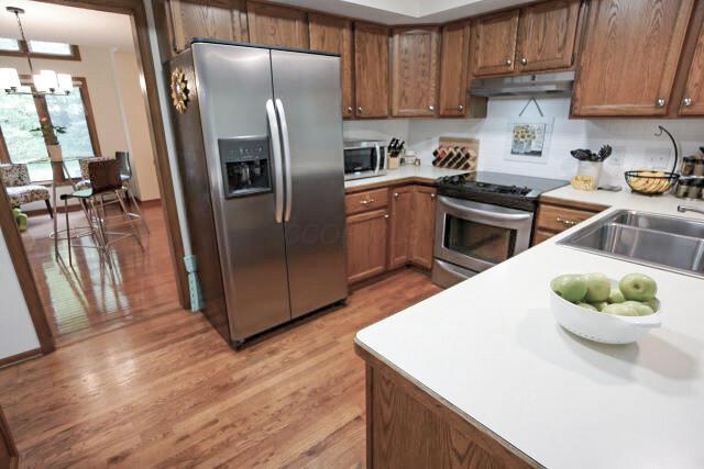 532 Woodview Rd, Westerville, OH 43081 - kitchen with appliances with stainless steel finishes, under cabinet range hood, light wood finished floors, brown cabinets, and light countertops