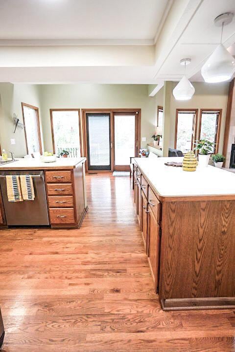 532 Woodview Rd, Westerville, OH 43081 - kitchen featuring stainless steel dishwasher, brown cabinets, light wood-type flooring, pendant lighting, and light countertops