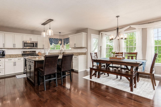 4381 Grathrine Ct, Lewis Center, OH 43035 - kitchen with appliances with stainless steel finishes, a chandelier, white cabinets, dark wood-style flooring, and light stone counters