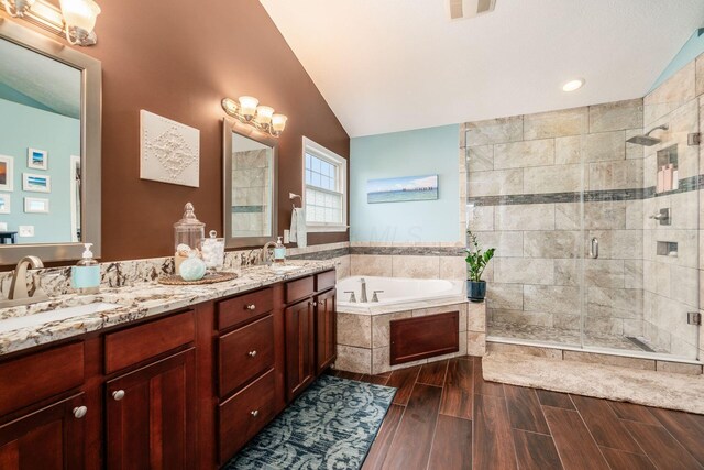 4381 Grathrine Ct, Lewis Center, OH 43035 - bathroom with a shower stall, a bath, vaulted ceiling, wood finished floors, and double vanity