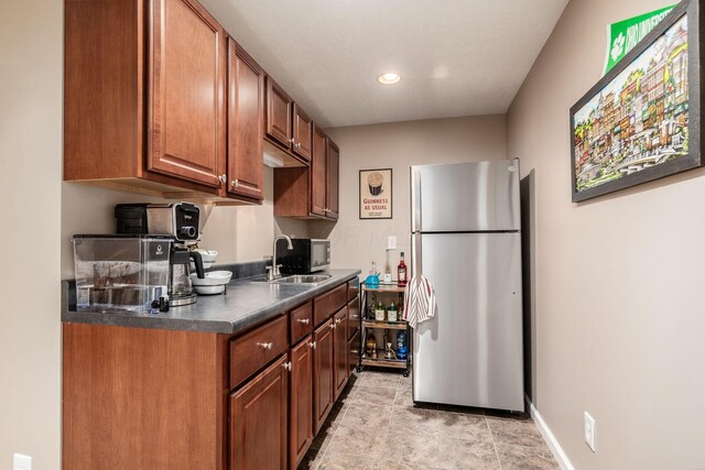4381 Grathrine Ct, Lewis Center, OH 43035 - kitchen with freestanding refrigerator, a sink, dark countertops, brown cabinetry, and recessed lighting