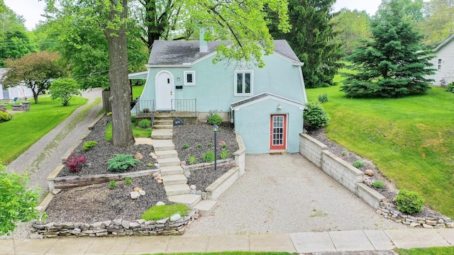 651 Eastern Ave, Bellefontaine, OH 43311 - view of front facade with stucco siding, a front yard, and a shingled roof