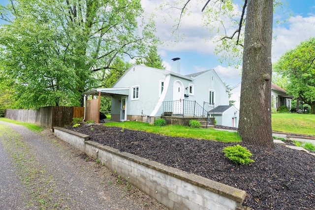 651 Eastern Ave, Bellefontaine, OH 43311 - view of front facade with fence and stucco siding