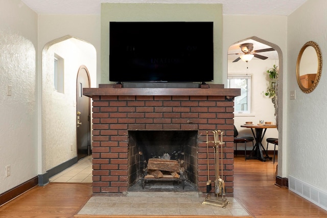 651 Eastern Ave, Bellefontaine, OH 43311 - detailed view of wood finished floors, a fireplace, ceiling fan, arched walkways, and a textured wall