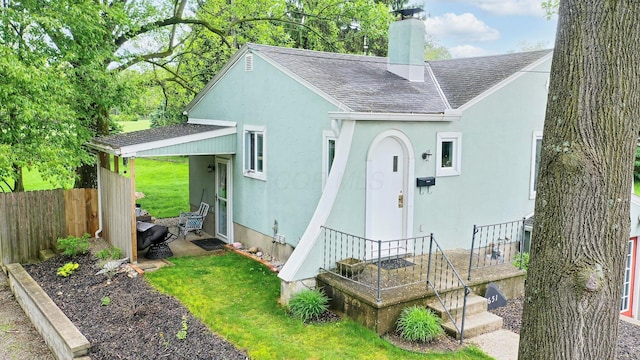 651 Eastern Ave, Bellefontaine, OH 43311 - back of house featuring a shingled roof, stucco siding, and a chimney