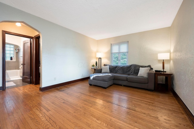 651 Eastern Ave, Bellefontaine, OH 43311 - living area featuring arched walkways, light wood-style floors, baseboards, and a textured wall