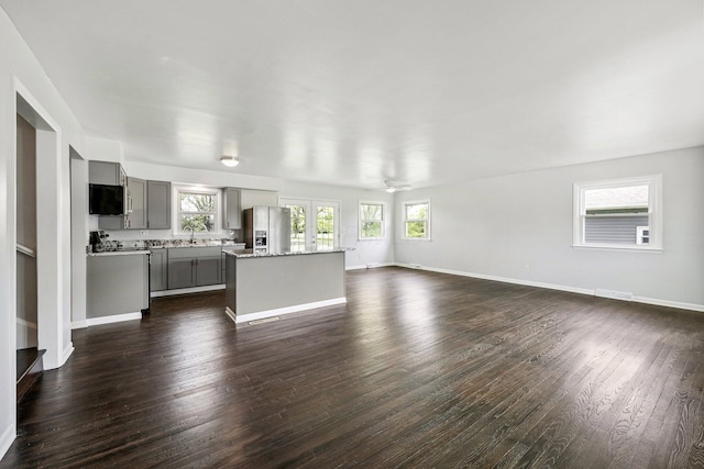 86 Arlington Ave, London, OH 43140 - unfurnished living room featuring healthy amount of natural light, dark wood finished floors, a sink, and baseboards