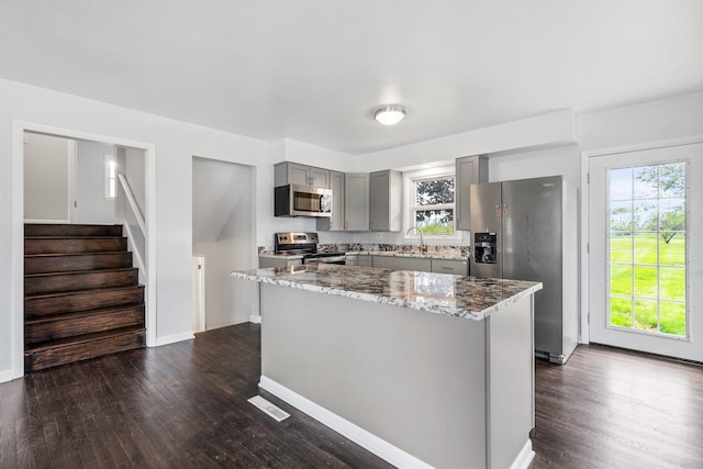 86 Arlington Ave, London, OH 43140 - kitchen with gray cabinets, stainless steel appliances, a sink, light stone counters, and dark wood-style flooring