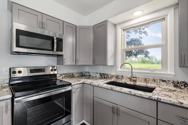 86 Arlington Ave, London, OH 43140 - kitchen featuring appliances with stainless steel finishes, gray cabinetry, a sink, and light stone countertops