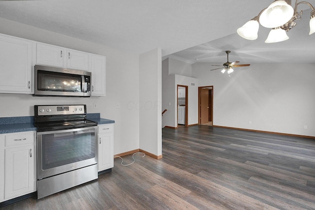 7209 Oliver Winchester Dr, Canal Winchester, OH 43110 - kitchen featuring appliances with stainless steel finishes, dark countertops, dark wood-style flooring, white cabinets, and lofted ceiling