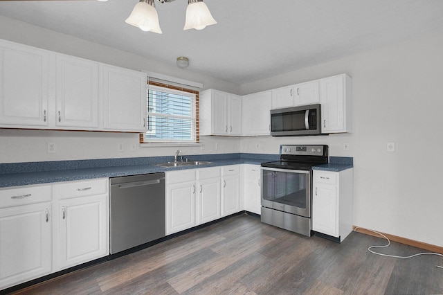 7209 Oliver Winchester Dr, Canal Winchester, OH 43110 - kitchen featuring appliances with stainless steel finishes, a sink, dark countertops, dark wood finished floors, and white cabinets