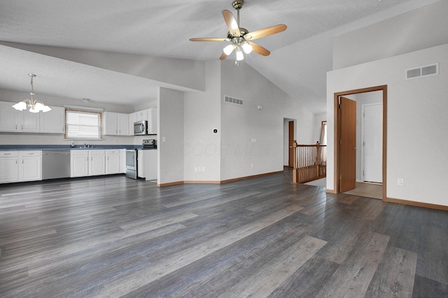 7209 Oliver Winchester Dr, Canal Winchester, OH 43110 - unfurnished living room with vaulted ceiling, a chandelier, a sink, a ceiling fan, and dark wood-style floors