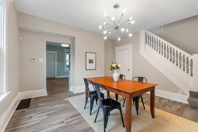 581 Kelton Ave, Columbus, OH 43205 - dining room with a chandelier, light wood-style flooring, baseboards, and stairs