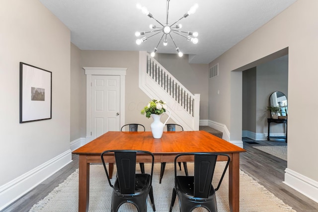 581 Kelton Ave, Columbus, OH 43205 - dining space with a chandelier, stairway, wood finished floors, and baseboards
