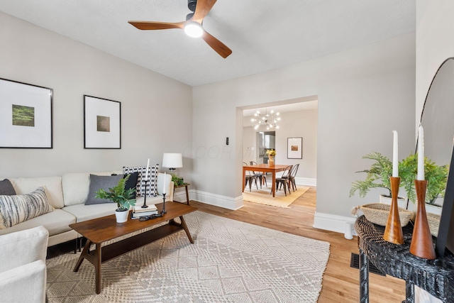 581 Kelton Ave, Columbus, OH 43205 - living room featuring light wood-style floors, a chandelier, baseboards, and a ceiling fan