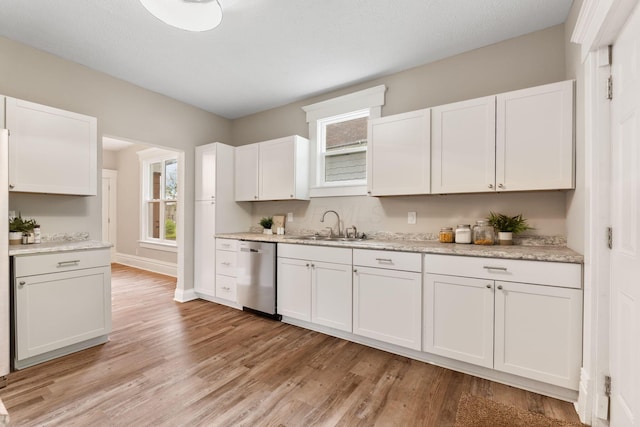581 Kelton Ave, Columbus, OH 43205 - kitchen featuring dishwasher, a sink, white cabinetry, light wood-style floors, and baseboards