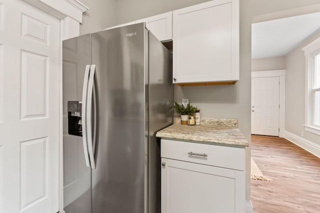 581 Kelton Ave, Columbus, OH 43205 - kitchen with stainless steel refrigerator with ice dispenser, light wood-type flooring, white cabinetry, baseboards, and light stone counters