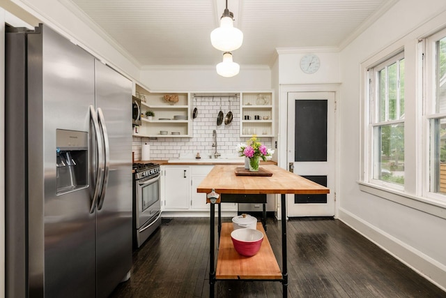 kitchen featuring appliances with stainless steel finishes, butcher block countertops, open shelves, crown molding, and decorative backsplash