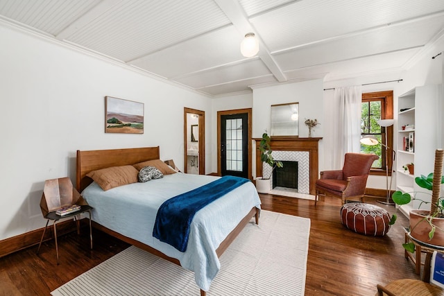 bedroom featuring coffered ceiling, wood-type flooring, baseboards, beamed ceiling, and a tiled fireplace