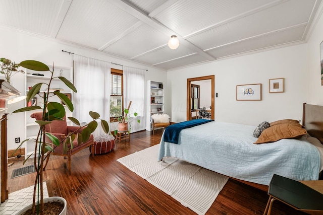 bedroom featuring wood-type flooring and beamed ceiling