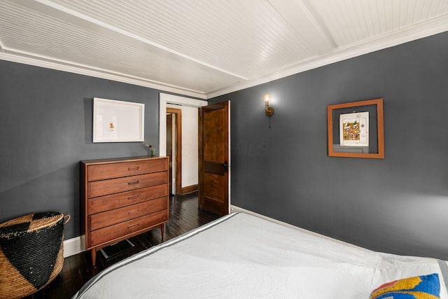 bedroom with hardwood / wood-style flooring, baseboards, and crown molding