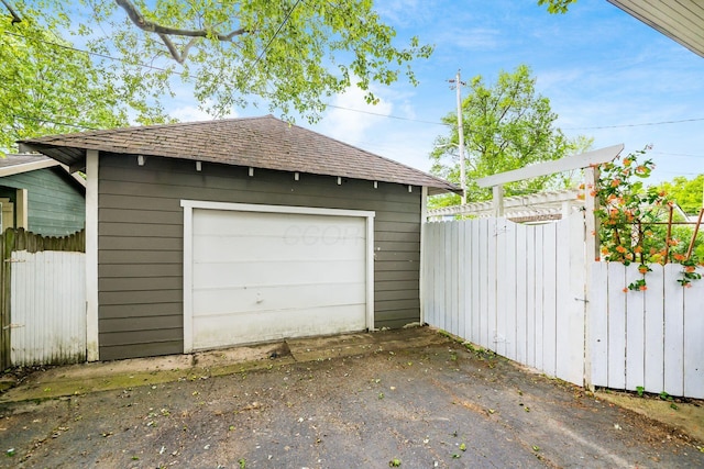 detached garage with fence and driveway