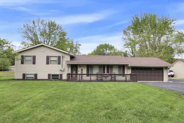 split level home featuring a garage, a front yard, and asphalt driveway