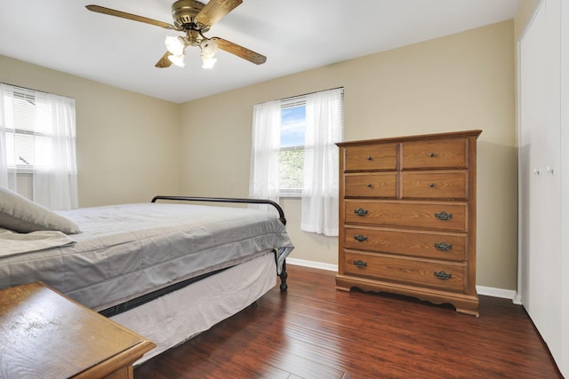bedroom with dark wood-type flooring, baseboards, and a ceiling fan