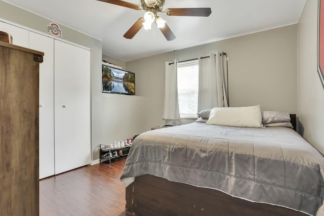 bedroom featuring wood finished floors, a closet, baseboards, and ceiling fan