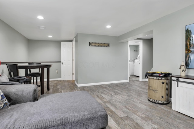 living area featuring wood finished floors, baseboards, and recessed lighting