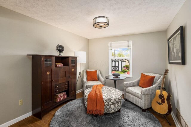 3690 Christopher Pl, Grove City, OH 43123 - sitting room featuring dark wood finished floors, baseboards, and a textured ceiling